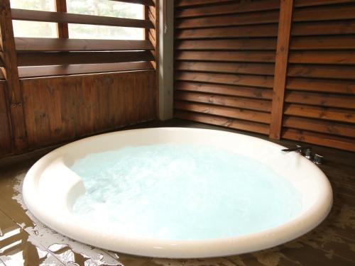 eine große Badewanne in einem Zimmer mit Fenster in der Unterkunft Cottage All Resort Service / Vacation STAY 8441 in Inawashiro
