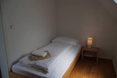 een klein bed in een kamer met een lamp op een tafel bij An de Bahn - Wohnen im historischen Gebäude in Wettringen