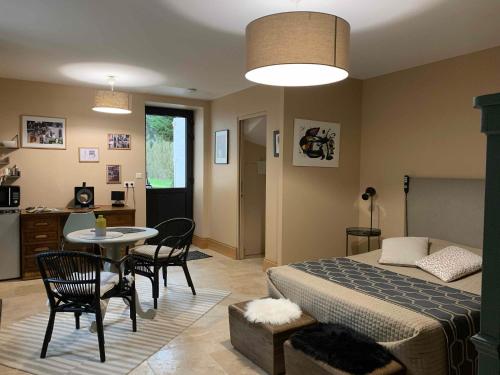 a bedroom with a bed and a table and chairs at EN VILLE À LA CAMPAGNE in Louhans