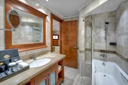 a bathroom with a sink and a tub and a shower at Donatello Hotel in Dubai