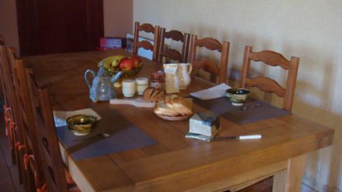 Una mesa de madera con un bol de fruta encima. en Les Gallerands, en Bessais-le-Fromental