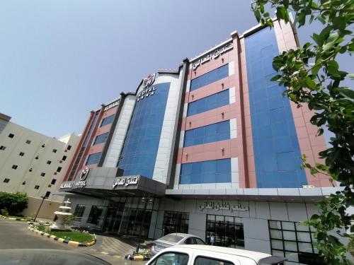 Al Maali Hotel Jazan في جازان: مبنى متوقف امامه سيارة