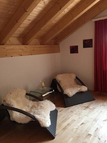 a room with two chairs in a attic at Ferienwohnung Lenzerheide-Vazerol in Brienz-Brinzauls