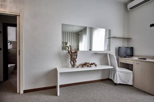 a living room with a white table and a mirror at Rouge Hotel International in Milano Marittima