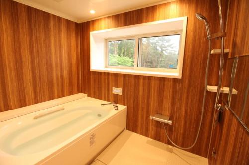 een badkamer met een bad en een raam bij Cottage All Resort Service / Vacation STAY 8444 in Inawashiro