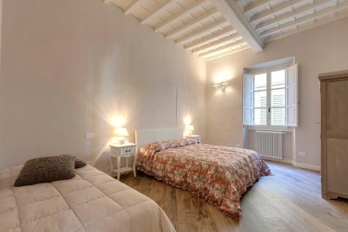 a bedroom with two beds and a window at Lambert Apartment in Florence