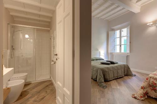 a bedroom with a bed and a bathroom with a shower at Lambert Apartment in Florence