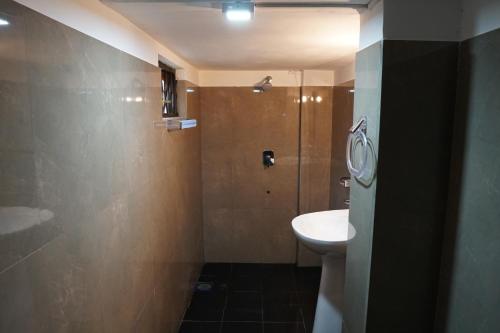 a bathroom with a sink and a shower and a toilet at Thiranagama Beach Hotel in Hikkaduwa