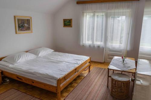 a bedroom with a large bed and a table at APARTMA JANŠA in Bled