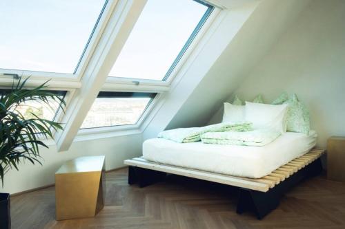 Habitación con cama en un ático con ventanas en Blackriver Loft Vienna mit gratis Parkplatz nahe Schönbrunn und U6 en Viena