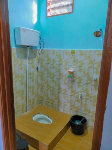 a bathroom with a toilet in a tiled wall at Teratak Aqish, Besut Terengganu in Kampong Gong Pauh