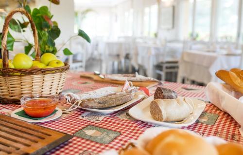a table with plates of food and a basket of bread at Hotel Ancora in Palamós