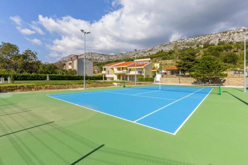 a tennis court in front of a house at Villa Delmati in Tugare