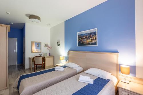 1 dormitorio con 2 camas y pared azul en Hotel Element, en Moscú