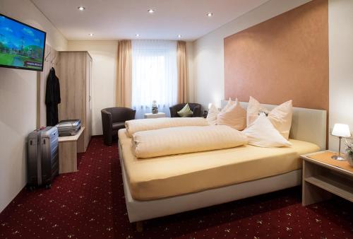 Cette chambre comprend deux lits et une télévision. dans l'établissement Hotel Gasthof Zur Post, à Königstein in der Oberpfalz