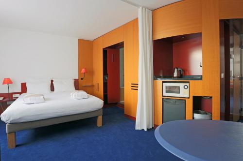 Habitación de hotel con cama y cocina en Novotel Suites Nancy Centre, en Nancy