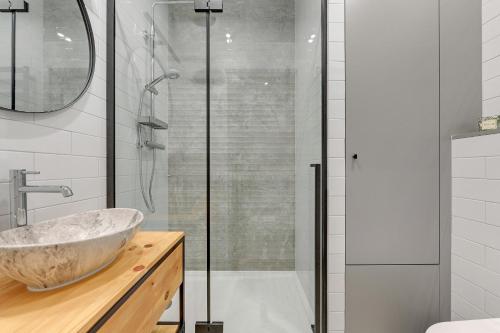 een badkamer met een wastafel en een douche bij Grand Apartments - Garden Gates in Gdańsk