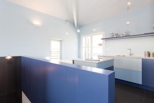 une grande cuisine avec des comptoirs blancs et des armoires bleues dans l'établissement Top floor2 beds w/sea wiew, à Cannes
