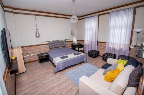 uma sala de estar com uma cama e um sofá em Huge Stylish Apartment Monroe 1 / City Centre em Plovdiv