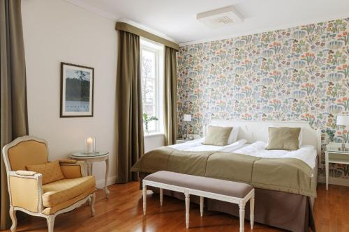 a bedroom with a bed and a chair at Lejondals Slott in Bro