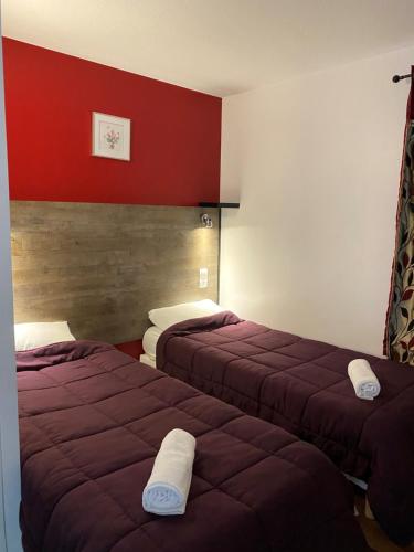 two beds in a hotel room with red walls at Fast Hotel Brie-Comte-Robert in Brie-Comte-Robert