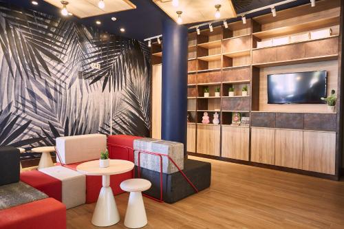 a living room with a red couch and a tv at Ibis Elche in Elche