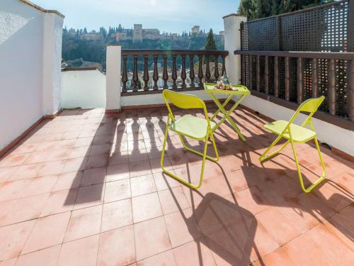 d'une terrasse avec des chaises jaunes et une table sur un balcon. dans l'établissement Holiday Home Carmen Del Agua by Interhome, à Grenade