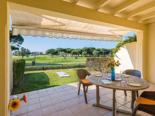 a patio with a table and chairs and a view of the park at Holiday Home Brisamar - Novo Sancti Petri by Interhome in Chiclana de la Frontera