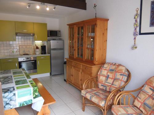 a kitchen with a table and a chair and a table at Holiday Home Les Capellanes by Interhome in Saint-Cyprien-Plage