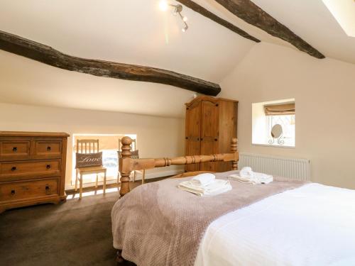 a bedroom with a large bed and a wooden dresser at The Cottage Glossop in Glossop