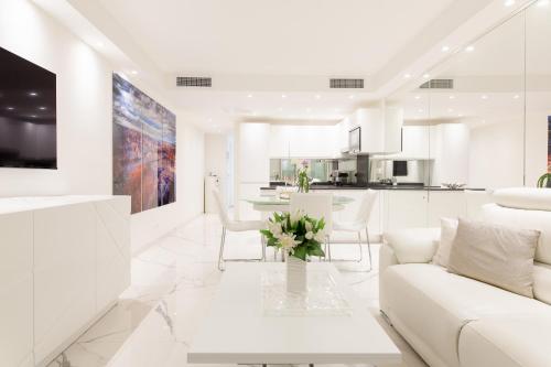 un salon blanc avec un canapé blanc et une table dans l'établissement On La Croisette: new 2 bedrooms with sea view, à Cannes