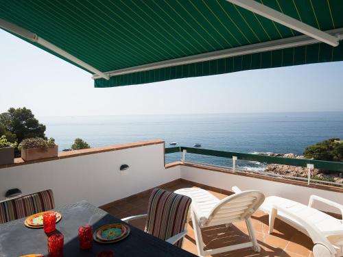 a balcony with a table and chairs and the ocean at Apartment Cala Salionc by Interhome in Cañet de Mar