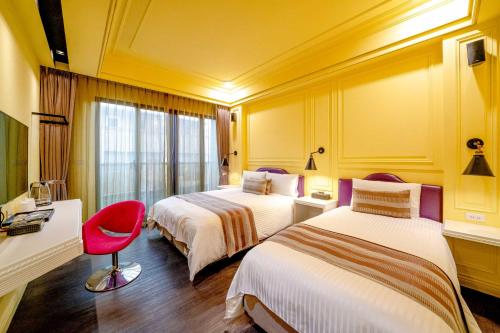 una stanza d'albergo con due letti e una sedia rossa di Dream B&B a Luodong