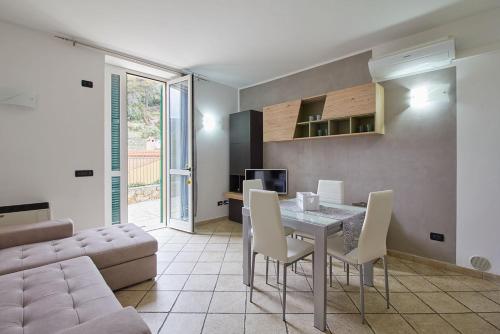 Appartamento Ulivo في فينالي ليغوري: غرفة معيشة مع طاولة وكراسي وأريكة