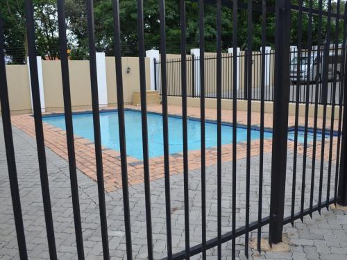 a fence next to a swimming pool at Henry George Guest House in Pretoria