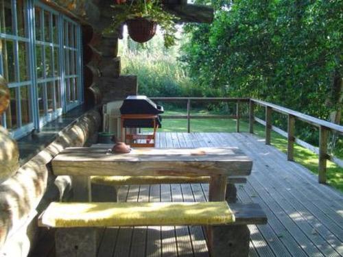 una terrazza in legno con tavolo e panca su un portico di Holiday Home Veijon kelo by Interhome a Korpilahti