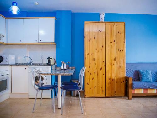 - une cuisine avec des murs bleus, une table et des chaises dans l'établissement Apartment Segrelles by Interhome, à Canet d'En Berenguer