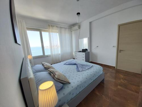 una piccola camera con letto e finestra di Two Worlds Sea View Apartment a Sarandë