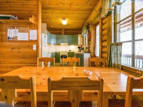a dining room with a large wooden table and chairs at Holiday Home Kallionnenä by Interhome in Mäkikylä