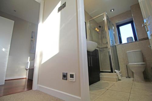 a bathroom with a toilet and a shower and a sink at The Barwoods - Modern Spacious Home in Chester - Parking in Chester