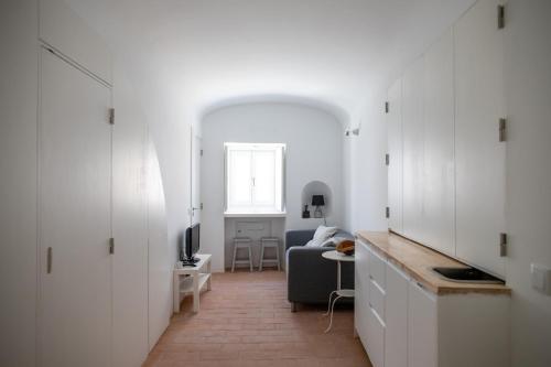 a living room with white cabinets and a couch at Casa da Travessa in Évora