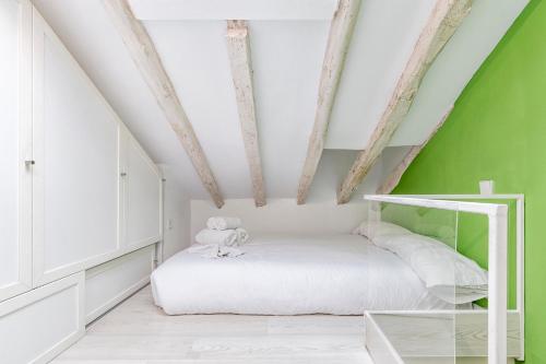 een slaapkamer met een wit bed en een groene muur bij Fabuloso estudio en pleno centro de Madrid. in Madrid