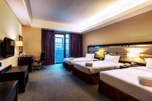 Säng eller sängar i ett rum på Ixora Hotel Penang