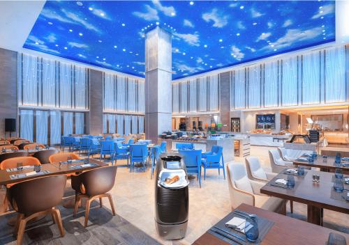 a restaurant with tables and chairs and a star ceiling at FlyZoo Hotel - Alibaba Future Hotel in Hangzhou