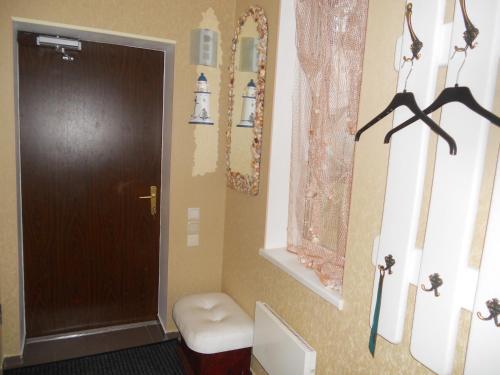 a bathroom with a toilet and a brown door at JURMALA ,экологический дом,2 этаж с отдельным входом in Jūrmala