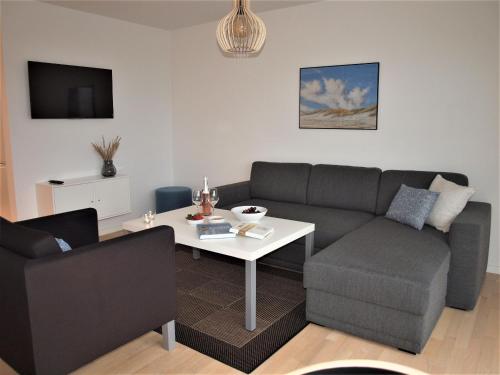 a living room with a couch and a table at Plesners Havnelejligheder in Skagen