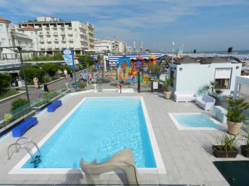 a swimming pool with a slide and a playground at Hotel Principe in Cattolica