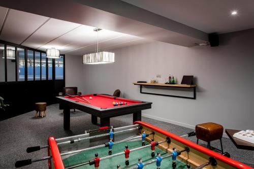 a living room with a pool table in the middle at L'Orée du Bois in Vittel