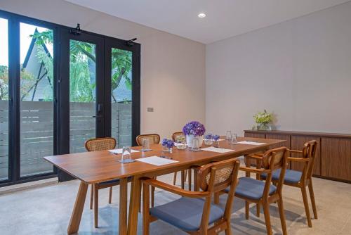 a dining room with a wooden table and chairs at Hanoman Hotel Kota Batu in Batu