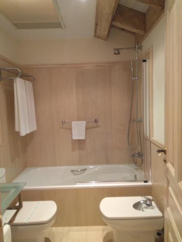 a bathroom with a tub and a toilet and a sink at Narbasu Restaurante y Hotel in Cereceda